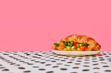 Pembe arka plan üzerinde sebze örtüsü olan taze pişmiş kruvasan. Sağlıklı. Antika, retro tarzı iç mekan. Yemek ve sanat fotoğrafçılığı. Tamamlayıcı renkler. İlan, metin için boşluk kopyala