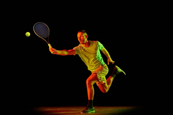 에너지와 활력넘치는 테니스 선수의 다이나믹 초상화가 어두운 배경에서 고립된 스포츠 — 스톡 사진