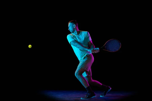 스튜디오에서 테니스 선수의 테니스를 연주하는 장면은 어두운 배경에서 고립되어 있었다 — 스톡 사진