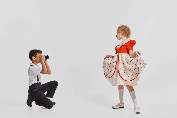 Portré Kisgyerekekről Fiú Fotózza Csinos Lányt Aranyos Ruhában Szürke Háttérrel — Stock Fotó