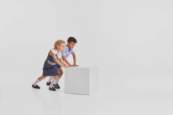 两个孩子的肖像 女孩在一起玩耍 把盒子隔离在灰色工作室的背景之外 创造力 复古风格 老式时尚 艺术的概念 — 图库照片