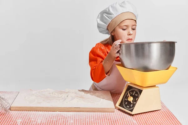 可爱的小孩 穿着厨师形象的女孩在灰色背景下做饭 测量面粉 创造力 复古风格 老式时尚 未来职业 艺术的概念 — 图库照片