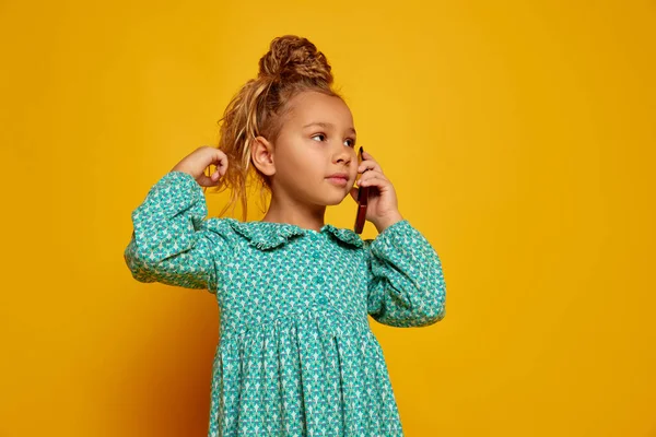 Mooie Kleine Meid Met Mobiele Telefoon Geïsoleerd Gele Studio Achtergrond — Stockfoto