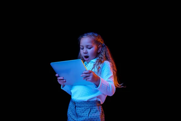 Mooi Uitziend Klein Meisje Met Laptop Geïsoleerd Donkere Achtergrond Neon — Stockfoto