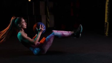 Abdominal egzersizler. Spor giyinen genç bir kadın spor salonunda neon ışık filtresiyle antrenman yapıyor. Güç ve kardiyo çalışması. Enerji, güç, spor ve sağlıklı yaşam tarzı kavramı