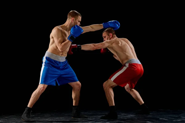 两名职业拳击手在运动制服拳击中的动态肖像在黑暗背景下被隔离 能量的概念 运动员看起来很有进取心 很活跃 — 图库照片