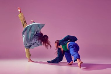 Modern deneysel danslar. Genç, şık, modaya uygun dans eden kadın. Pembe arka planda izole edilmiş bir şekilde. Modern sanat, moda, gençlik tarzı ve yaratıcılık kavramı