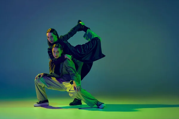 2人のダンサー スタイリッシュなファッショナブルなダンスカップルは ネオンの光の中でカラフルなグラデーション青緑の背景にコンテンポラリーダンスを踊る 創造性 ファッションの概念 — ストック写真