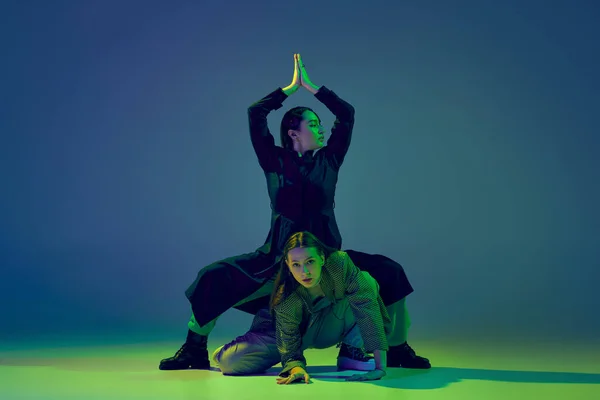 動いている感情 2人のダンサー スタイリッシュなファッショナブルなダンスカップルは ネオンの光の中でカラフルなグラデーション青緑の背景にコンテンポラリーダンスを踊る 創造性 ファッションの概念 — ストック写真
