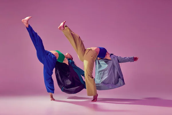 Way to future. Contemporary dance couple in motion and action isolated on crystal pink background. Young stylish fashionable girls dancing. Concept of modern art, fashion, youth style and creativity