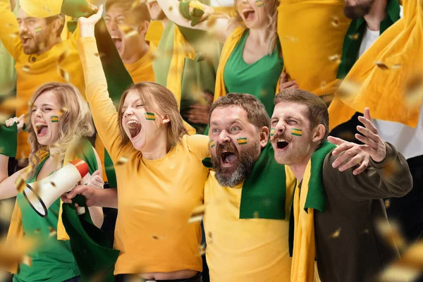 Shouting young people, thrilled excited soccer football fans cheering for their sport team at stadium. Concept of winner emotions, world sports competitions, championship. Green and yellow colors