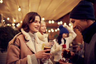 Noel tatili ve partilerde yeni tanıdıklar. Sıcak içeceklerle romantik bir randevuda mutlu bir adam ve kız. Duygular, tatiller, aşk, arkadaşlık kavramı. Neşeli ve mutlu görün.