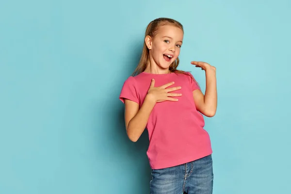 小さな美しい少女の肖像画 ピンクのTシャツの子供の青のスタジオの背景に孤立ポーズ 幸せと興奮しています 子供時代 ライフスタイルの概念 — ストック写真