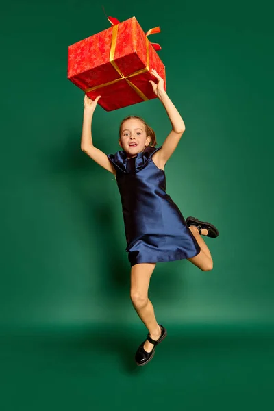 小美女的画像 穿着衣服的孩子摆着大礼品盒 与绿色的工作室背景隔离 面部表情 生活方式 圣诞节的概念 — 图库照片