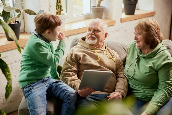 Oude Grootouders Met Kleinkind Die Thuis Bank Zitten Nieuws Lezen — Stockfoto
