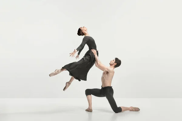 若い男性と女性 グレーのスタジオの背景に隔離されたステージ上で実行されるバレエダンサー 支援だ 古典舞踊の美学 美しさの概念 広告のコピースペース — ストック写真