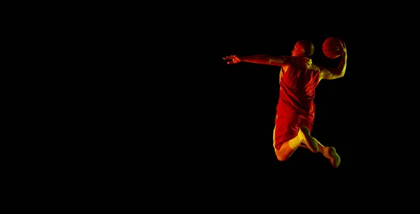 Basketbol Topuyla Atlayan Atletik Erkek Basketbolcu Ilanı Kırmızı Işıkta Koyu — Stok fotoğraf
