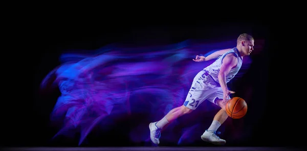 ドリブル ネオンライトフィルターで黒の背景に隔離されたボールと行動中の若い男 プロのバスケットボール選手 スポーツ エネルギー スキル チーム競争の概念 フライヤー — ストック写真