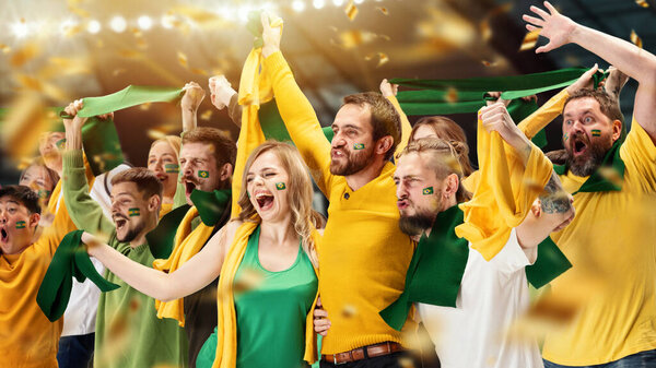 Expressive young people, thrilled excited soccer football fans shouting cheering for sport team at stadium. Concept of happy emotions, world sports competitions, championship. Green and yellow colors