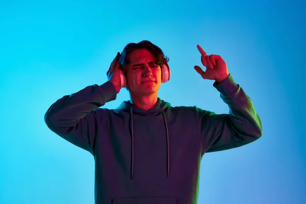 Kıvırcık Saçlı Genç Adamın Portresi Kulaklıkla Müzik Dinliyor Mavi Arka — Stok fotoğraf