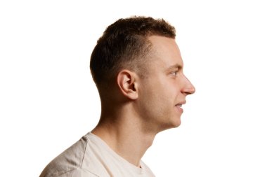 Beyaz tişörtlü bir adamın beyaz stüdyo arka planında izole edilmiş pozu. Şık bir saç kesimi ve pürüzsüz bir yüz. Erkek sağlığı, kendine bakım, vücut ve cilt bakımı kavramı. İlan için alanı kopyala