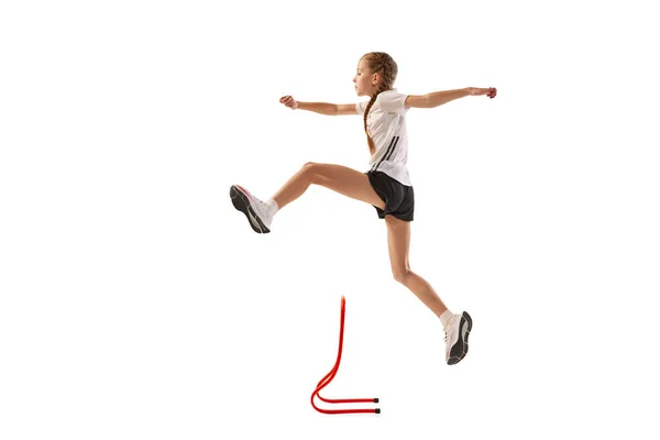 小さな女の子のダイナミックな肖像画 プロのアスリート ランナー 白い背景に隔離された急なトレーニングでジョギング スポーツ パワー スピード 競争の概念 — ストック写真