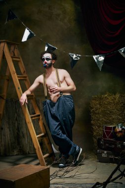 Kişisel bir trajedi yaşayan üzgün erkek palyaçonun kavramsal portresi, sahne arkasındaki eski sirkte umutsuzluk. Kader, iş, duygu, yüz ifadesi, akıl sağlığı kavramı.