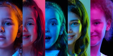 Çocukların duyguları işte. Çok renkli arka planda neon ışıkta izole edilmiş sevimli çocukların portreleri. Vay canına, duygular, yüz ifadesi ve tasasız çocukluk kavramı. Yakın çekim.