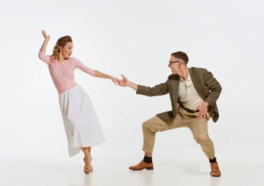 İki duygusal dansçı klasik tarzda giyinmiş dans eden salıncakta dans ediyor ve beyaz arka planda rock 'n roll yapıyor. Ebedi gelenekler, 1960 'ların Amerikan moda tarzı ve sanatı. Çift mutlu görünüyor, mutlu.