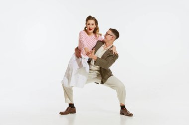 Mutlu, şık ve enerjik dansçıların dinamik portresi beyaz arka planda izole bir şekilde lindy hop ya da swing dansı yapıyor. Müzik, enerji, mutluluk, ruh hali, eylem, tarz kavramı