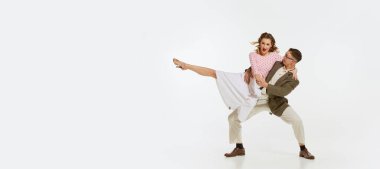 Mutlu, şık ve enerjik dansçıların dinamik portresi beyaz arka planda izole bir şekilde lindy hop ya da swing dansı yapıyor. Müzik, enerji, mutluluk, ruh hali, eylem, tarz kavramı. İlan için ilan