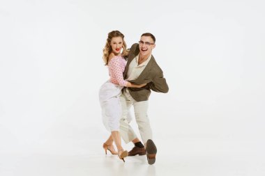 Hareket halindeki aşk. Beyaz arka planda izole edilmiş 60 'lı yılların moda kıyafetleri içinde dans eden genç ve heyecanlı erkek ve kadın. Müzik, enerji, mutluluk, ruh hali, eylem