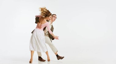Mutlu, şık ve enerjik dansçıların dinamik portresi beyaz arka planda izole bir şekilde lindy hop ya da swing dansı yapıyor. Müzik, enerji, mutluluk, ruh hali, eylem, tarz kavramı