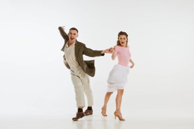 İki duygusal dansçı klasik tarzda giyinmiş dans eden salıncakta dans ediyor ve beyaz arka planda rock 'n roll yapıyor. Ebedi gelenekler, 1960 'ların Amerikan moda tarzı ve sanatı. Çift mutlu görünüyor, mutlu.