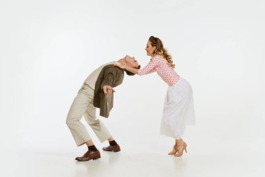 Mutlu, şık ve enerjik dansçıların dinamik portresi beyaz arka planda izole bir şekilde lindy hop ya da swing dansı yapıyor. Müzik, enerji, mutluluk, ruh hali, eylem, tarz kavramı