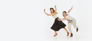 Mutlu, şık ve enerjik dansçıların dinamik portresi beyaz arka planda izole bir şekilde lindy hop ya da swing dansı yapıyor. Müzik, enerji, mutluluk, ruh hali, eylem, tarz kavramı