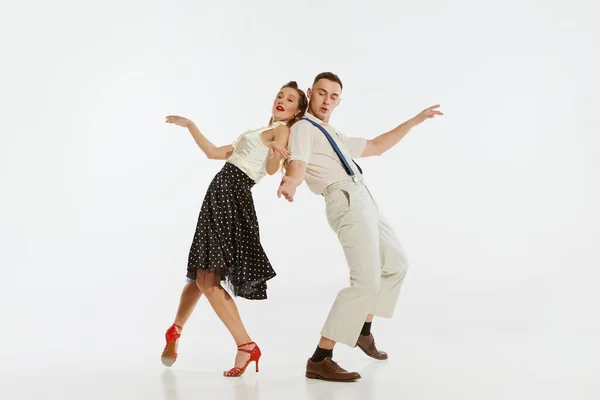 爱情在运动 年轻而兴奋的男女穿着60年代的美国时尚服装跳舞复古舞与白色背景隔离 — 图库照片