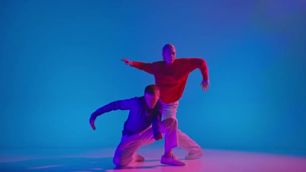 Müziği Şık Erkek Kadın Parlak Spor Kıyafetlerle Neon Işıkta Dans — Stok video