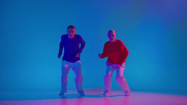 Wyraźna Para Tancerzy Sportowej Odzieży Tańczy Eksperymentalny Taniec Niebieskim Tle — Wideo stockowe