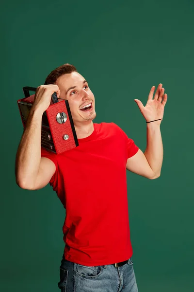 Portret Młodego Emocjonalnego Mężczyzny Luźnych Ciuchach Słuchającego Radia Odizolowanego Zielonym — Zdjęcie stockowe
