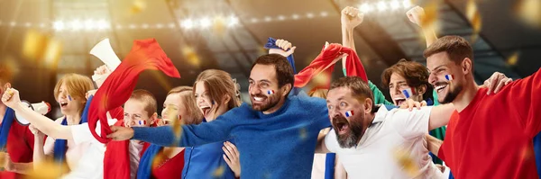 Group of emotive young people, football, soccer fans cheering french team at the stadium. Scoring winning goal. Concept of sport, cup, world, team, event, competition, emotions, hobby
