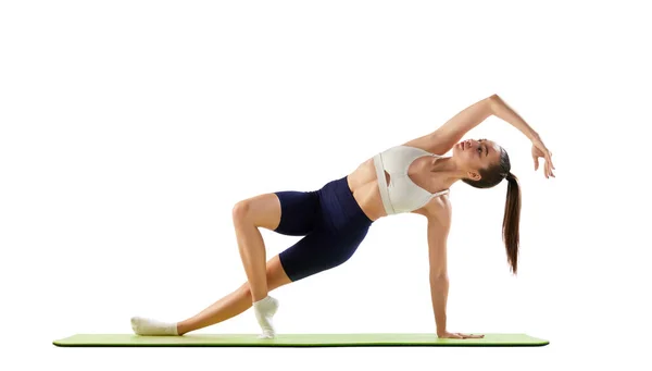 年轻女运动员的肖像训练 做伸展运动 侧板隔离在白色背景之上 运动的概念 身体护理 — 图库照片