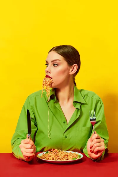 小女孩吃意大利面 面条在黄色背景下从嘴里伸出来 晚餐时间 意大利美食爱好者 食品流行艺术摄影 互补的颜色 文字的复制空间 — 图库照片