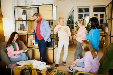 Yenilikler. Çalışanlardan oluşan bir grup, erkek ve kadınlar, toplantı yapıyorlar, ofiste, içeride tartışıyorlar. İş, beyin fırtınası, eğitim, takım çalışması, girişim ve şirket geliştirme kavramı