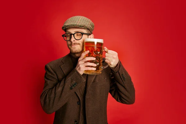 Stylový Muž Klasických Šatech Pózující Sklenicí Pěnového Piva Izolovaného Červeném — Stock fotografie