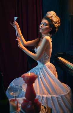 Ortaçağ insanı suretinde güzel bir genç kadın portresi, yumuşak beyaz elbiseli müzisyen piyanonun başında yeni müzik besteleriyle oturuyor. Dönem, güzellik, tarih, sanat, yaratıcılık karşılaştırması.