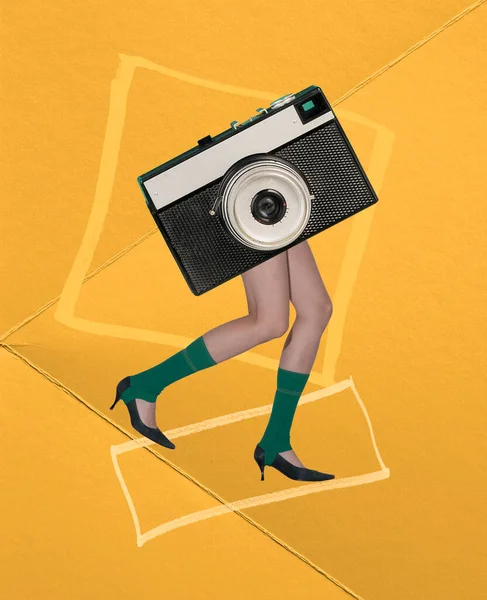 Contemporary art collage. Creative design. Shooting. Female legs in green socks on heels with vintage camera instead body over yellow background. Inspiration, idea, trendy magazine style, surrealism.
