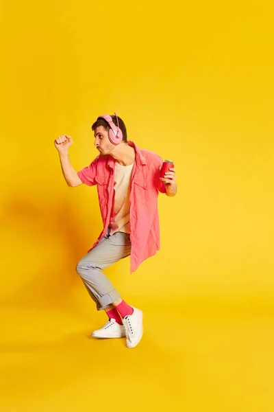 Morsom Ung Mann Rosa Skjorte Dansende Hodetelefoner Isolert Livaktig Gul – stockfoto