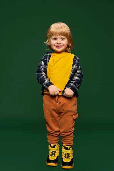 可爱小男孩的肖像 穿着时髦休闲装的孩子 在绿色工作室的背景上摆出一副笑脸 童年的概念 生活方式 广告的复制空间 — 图库照片