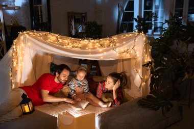 Sevgi dolu bir aile, anne, baba ve kız kendi kendini yetiştirmiş bir kulübede uzanıyor, akşamları çadır kuruyor ve kitap okuyor. Masallar. Fantezi, çocukluk, aile, boş zaman, aşk, bakım, ev.